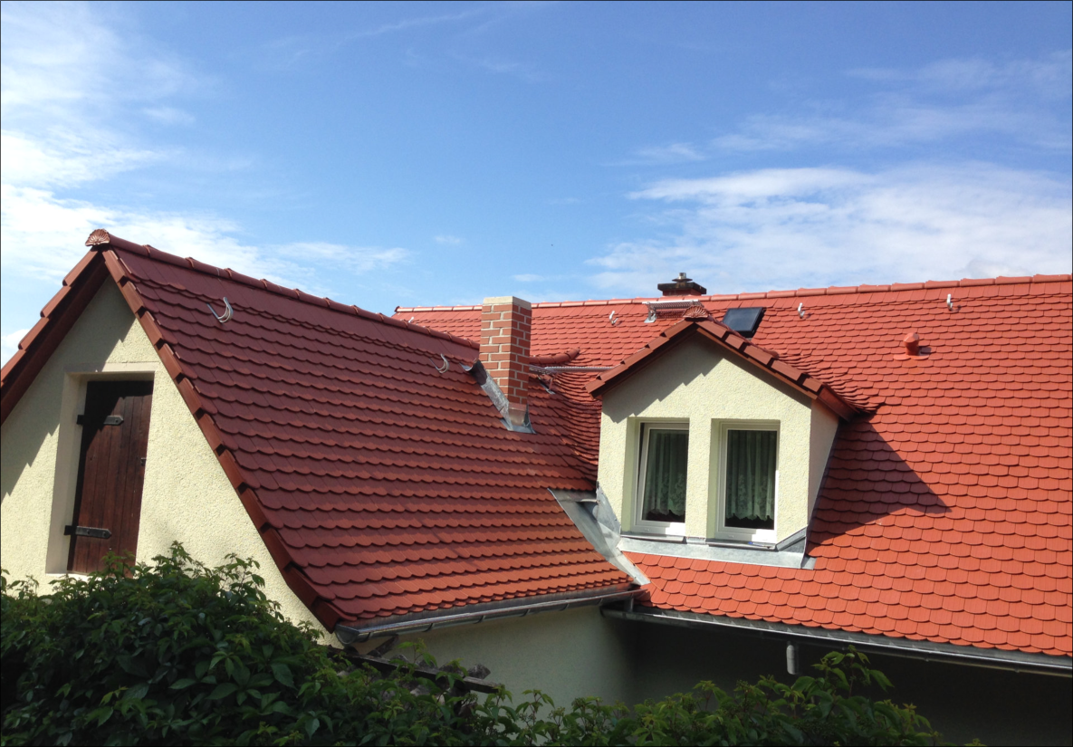 Fertiggestelltes Satteldach mit roten Ziegeln