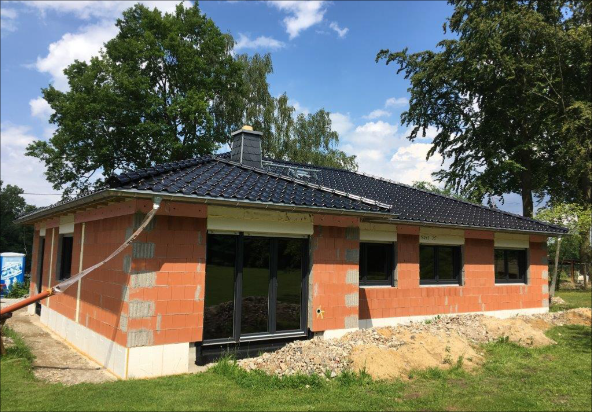 Massivbau im Rohbau mit neu eingedecktem Dach